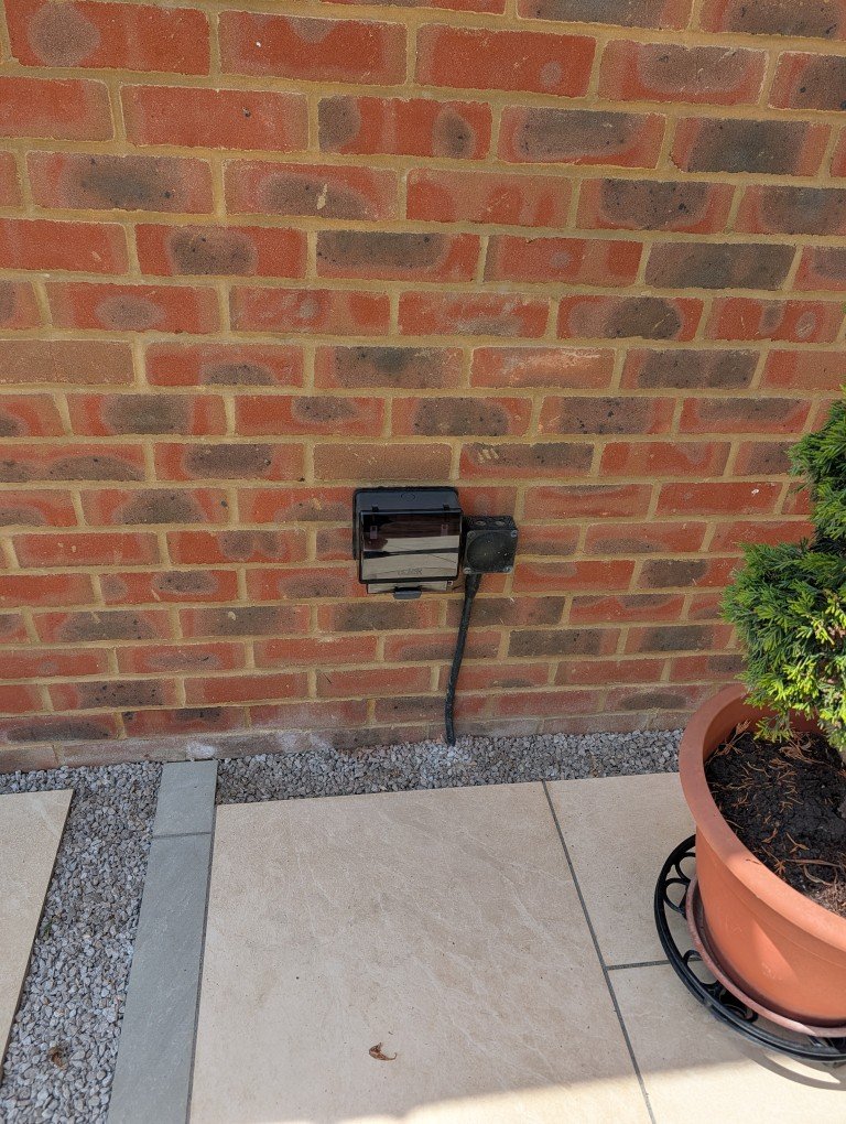 Weatherproof outdoor socket on a garden wall